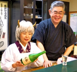 なじみ客から贈られた鬼嫁のかつらを付ける相沢孝香さん(左)と夫の一智さん(仙台市の「我流伊達屋敷」)