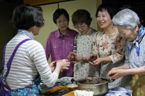 「玉ねぎツアー」のために友人とぼた餅作りに精を出す露木サヨ子さん(右から2人目)