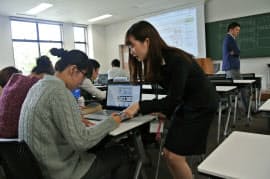 大学3年の山口さん(中)は週2回、学生目線で授業を補佐する