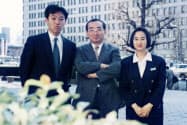 「おかしい」を原動力に仕事の進め方や制度を変えていった(中央が本人、旧丸ビル前で)