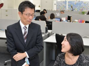 同僚と打ち合わせする日本IBMの川田篤さん(左)