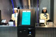 人手を限界まで減らす「変なホテル」では、フロントでロボットがお客を出迎える（東京都港区）