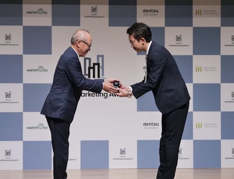 日本経済新聞社の渡辺洋之専務(左)から大賞を受賞したパーソルホールディングスの繁田佳典氏にトロフィーが贈られた。