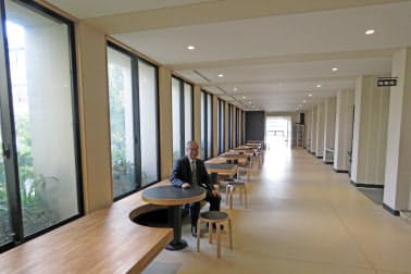 灘中学・高校の職員室前の広すぎる廊下にはテーブルやいすもある。中央は和田校長