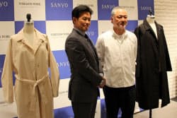 新しいコートを発表する岩田功社長(左)と、デザイナーの森下公則氏（2017年5月25日、東京都中央区）
