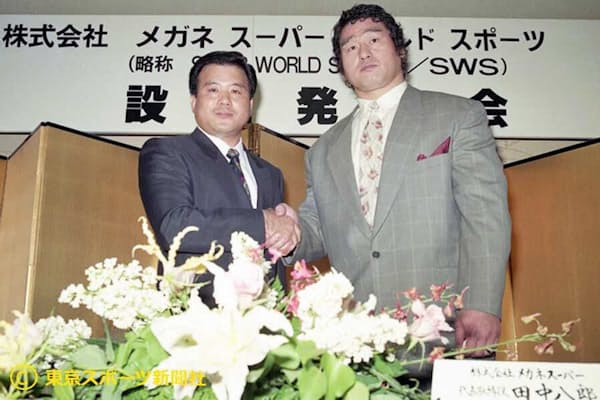 SWS設立会見で握手する天龍氏とメガネスーパーの田中八郎社長（1990年5月10日、都内）=東京スポーツ新聞社提供