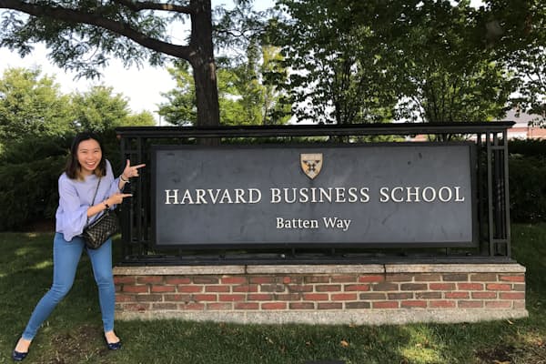 ハーバードビジネススクールの校標前でほほ笑むエイミー・アサワテワウィスさん