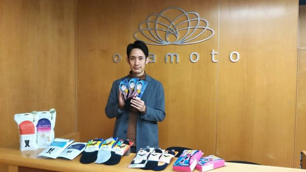 岡本のレッグウエアの商品ラインアップは幅広い(中央はマーケティング担当の青柳一輝氏)